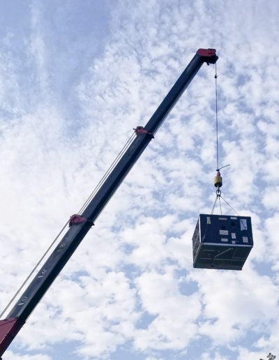 Large crane lifting rooftop HVAC unit